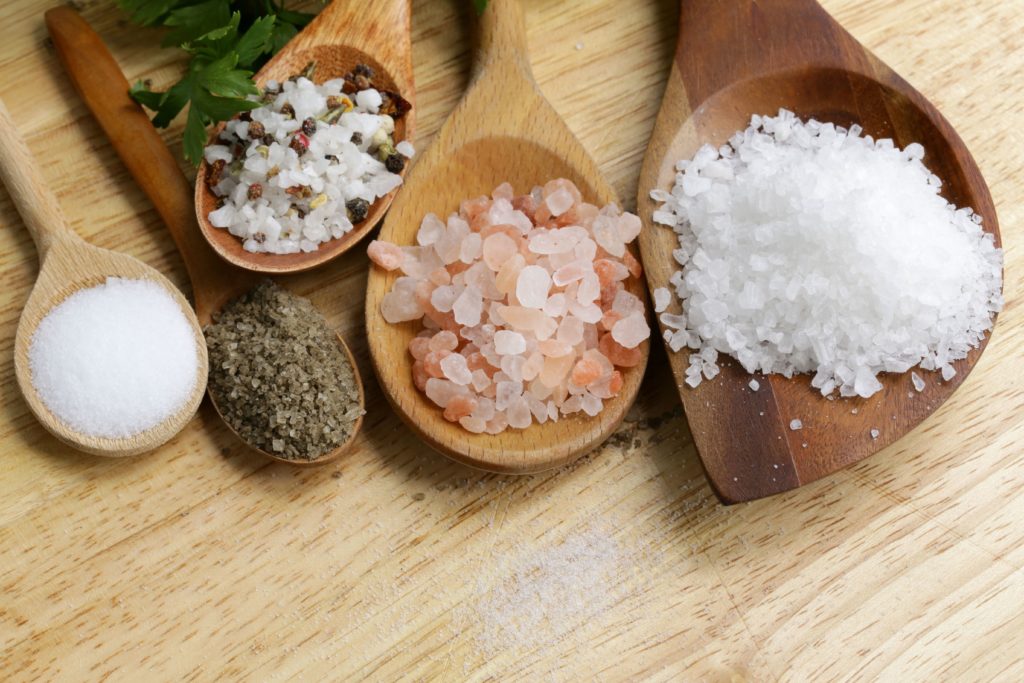 different types of salt on wooden spoons